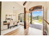 Open dining room with hardwood floors, modern lighting, and a view to the outside at 6422 Chimney Bluff Rd, Lancaster, SC 29720