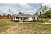 Charming one-story home features an inviting front porch and beautiful landscaping at 7514 Secrest Shortcut Rd, Indian Trail, NC 28079