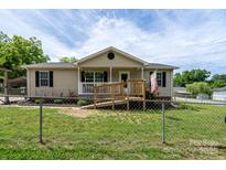 Charming single-story home with a welcoming front porch and ramp, surrounded by a well-maintained lawn at 907 Bethpage Rd, Kannapolis, NC 28081