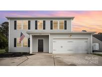 Two-story home with gray siding, black shutters, an American flag, and a two-car garage at 1436 Yellowstone Ct, Gastonia, NC 28054