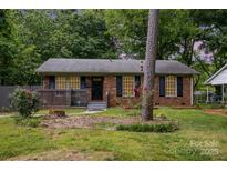 Charming brick home featuring a covered porch and well-maintained front yard, creating curb appeal at 1519 Briarfield Dr, Charlotte, NC 28205