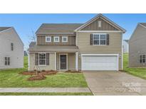 Charming two-story home with a two-car garage, landscaped front yard, and classic architectural details at 1532 Cottage Creek Dr, Bessemer City, NC 28016