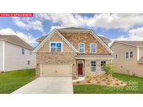 Beautiful home exterior featuring a brick and stone facade, well-manicured lawn, and an attached two-car garage at 156 Ventor Way, Mooresville, NC 28115
