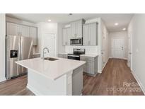 Bright kitchen features stainless steel appliances, gray cabinetry, and a center island with a sink at 1721 Braemar Village Dr, Monroe, NC 28110