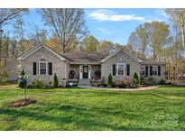 Charming brick ranch home with manicured lawn, mature trees, and welcoming front entry at 235 Stafford Estates Dr, Salisbury, NC 28146