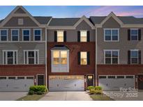 Charming townhome with brick facade, gray siding, and a one-car garage offers comfortable living at 2619 Grantham Place Dr, Fort Mill, SC 29715