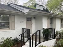 Charming front entrance with black railings, brick facade, and neutral door at 2701 Rea Rd, Charlotte, NC 28226