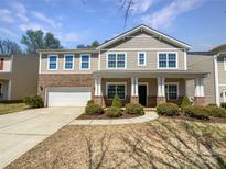 Charming two-story home featuring a brick and siding exterior, attached garage, and well-manicured front yard at 3026 S Devon St, Charlotte, NC 28213