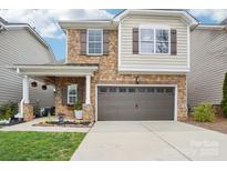 Charming two-story home featuring a stone facade, attached two-car garage, and a beautifully landscaped front yard at 4433 Forest Gate Ln, Charlotte, NC 28270