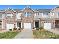 Charming brick and vinyl townhome with attached garage and well-maintained landscaping at 4528 Craigmoss Ln, Charlotte, NC 28278