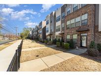 A view of modern townhomes with brick facades and manicured landscaping on a sunny day at 532 Billingsley Rd, Charlotte, NC 28211