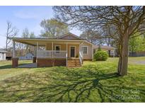 Charming single-story home with a cozy front porch and well-maintained lawn in a quaint neighborhood at 61 Brown Sw St, Concord, NC 28027