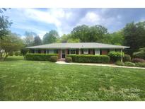 Charming brick home with a well-manicured lawn and lush greenery, offering great curb appeal at 8608 Cedarbrook Dr, Charlotte, NC 28215
