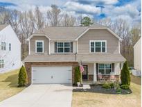 Charming two-story home with a well-manicured lawn, a two-car garage, and a welcoming front porch at 10694 Sapphire Trl, Davidson, NC 28036