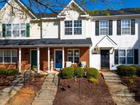 Charming townhouse with inviting brick accents, a blue front door, and well-maintained landscaping at 107 Forester St, Mooresville, NC 28117