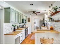 Bright kitchen features custom sage cabinets, butcher block countertops, stainless appliances, and stylish decor at 2175 Highwood Rd, Rock Hill, SC 29732