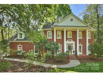 Traditional brick home with a columned front porch and manicured landscaping at 2605 Winding Oak Dr, Charlotte, NC 28270