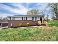 Charming split-level home featuring a brick facade and recently stained wooden porch with lush front yard at 3791 Richard St, Claremont, NC 28610