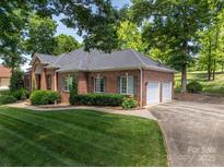 Brick home featuring an attached garage and a well-maintained lawn at 3964 Deer Run Ne Dr, Conover, NC 28613