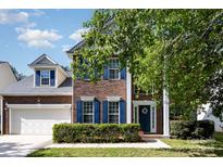 Charming brick two-story home with blue shutters, a well-kept lawn, and attached two-car garage at 10429 Madison Park Dr, Charlotte, NC 28269