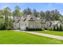 Charming two-story home boasts lush landscaping, attached garage and well manicured lawn at 125 Trent Pines Dr, Mooresville, NC 28117
