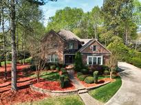 Beautiful brick home with manicured lawn, lush landscaping, and a welcoming walkway to the front door at 13620 Castleford Dr, Mint Hill, NC 28227