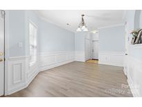 Bright dining room featuring wood floors, a modern chandelier, and detailed wainscoting at 1386 21St Ne Ave, Hickory, NC 28601