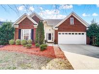 Charming brick home with well-manicured landscaping and an attached two-car garage at 2020 Makin Dr, Indian Trail, NC 28079