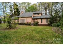 Charming two-story home with a well-maintained lawn, mature trees, and beautiful landscaping at 2131 Wildlife Rd, Charlotte, NC 28214