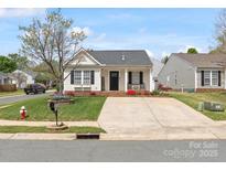 Charming single-story home featuring a well-manicured lawn, concrete driveway, and cozy front porch at 3020 Salmon River Dr, Monroe, NC 28110