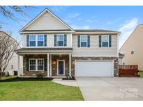 Charming two-story home with stone accents, a well-manicured lawn, and a two-car garage at 326 Nantucket Way, Rock Hill, SC 29732