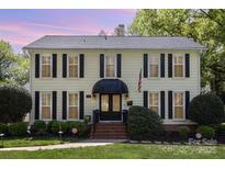 Charming yellow two-story house with black shutters and a well-manicured front yard at 3916 Riverbend Rd, Charlotte, NC 28210