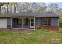 Charming single-story home with blue siding, red shutters, and a covered front porch at 6005 Fringe Tree Dr, Charlotte, NC 28227