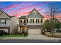 Home boasts a stone and siding exterior, complemented by black shutters and a neatly kept front lawn at 6020 Union Pacific Ave, Charlotte, NC 28210