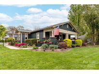 Charming home featuring a beautifully landscaped front yard with colorful flowers and inviting front porch at 803 Catawba St, Belmont, NC 28012