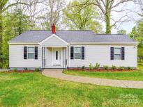Charming home with a well-manicured lawn, gray roof, black shutters, and welcoming front door at 809 N Ransom St, Gastonia, NC 28052