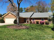Charming brick home featuring a manicured lawn and beautiful landscaping at 9539 Errington Ln, Mint Hill, NC 28227