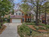 Charming two-story brick home with a well-manicured front yard and an attached two-car garage at 108 Kinderston Dr, Davidson, NC 28036