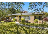 Charming brick home with a well-manicured lawn, mature landscaping, and inviting walkway at 110 Tanglewood Dr, Kannapolis, NC 28081