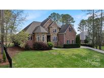 Charming two-story home features a stone and brick exterior with manicured landscaping and mature trees at 116 Whispering Cove Ct, Mooresville, NC 28117