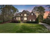 Charming two-story brick and stone home with lush landscaping and a well-manicured lawn at 116 Whispering Cove Ct, Mooresville, NC 28117
