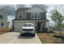 Charming two-story home featuring a gray exterior, two-car garage, and inviting front porch at 120 Parson Ln, Statesville, NC 28625