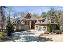 Stunning home boasts meticulous landscaping, a circular driveway, and a three-car garage at 1754 Brawley School Rd, Mooresville, NC 28117