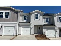 Charming townhome with white siding, attached garage, and well-maintained landscaping at 2060 Old Rivers Rd, Concord, NC 28027