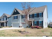 Charming two-story home with gray siding, black shutters, and a well-manicured front yard at 2097 Saddlebred Dr, Iron Station, NC 28080