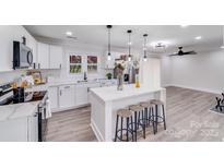 Modern kitchen featuring white cabinets, a center island, and stainless steel appliances at 2109 Tarlton Dr, Matthews, NC 28105