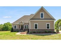 Charming single-Gathering home with stone accents, well-maintained lawn, and inviting covered front porch at 244 Alexis Lucia Rd, Alexis, NC 28006