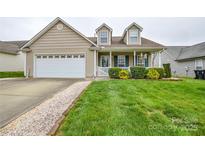 Charming beige house with a well-manicured lawn and inviting front porch at 2981 Deep Cove Nw Dr, Concord, NC 28027