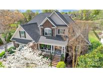 Inviting two-story home with a brick facade, covered porch, and lush landscaping in a quiet neighborhood at 4715 Amberside Dr, Rock Hill, SC 29732