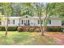 Charming single-story home with a well-maintained front yard, porch, and lush green trees, perfect for peaceful suburban living at 6575 Charlotte Hwy, York, SC 29745
